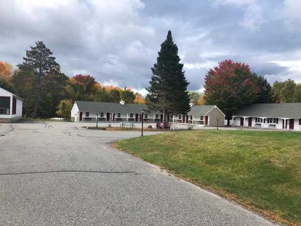 A motel with multiple rooms, a parking area, and a grassy lawn.
