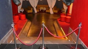 Un hall de hotel con alfombra roja, zonas de estar rojas y un mostrador de recepción.