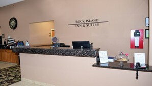 A reception desk at Rock Island Inn & Suites with a clock, a notice board, and a small display case. - Rock Island Inn & Suites (Atlantic)