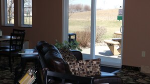 A cozy living area with a leather couch, a patterned pillow, and a dining table with chairs. - Rock Island Inn & Suites (Atlantic)
