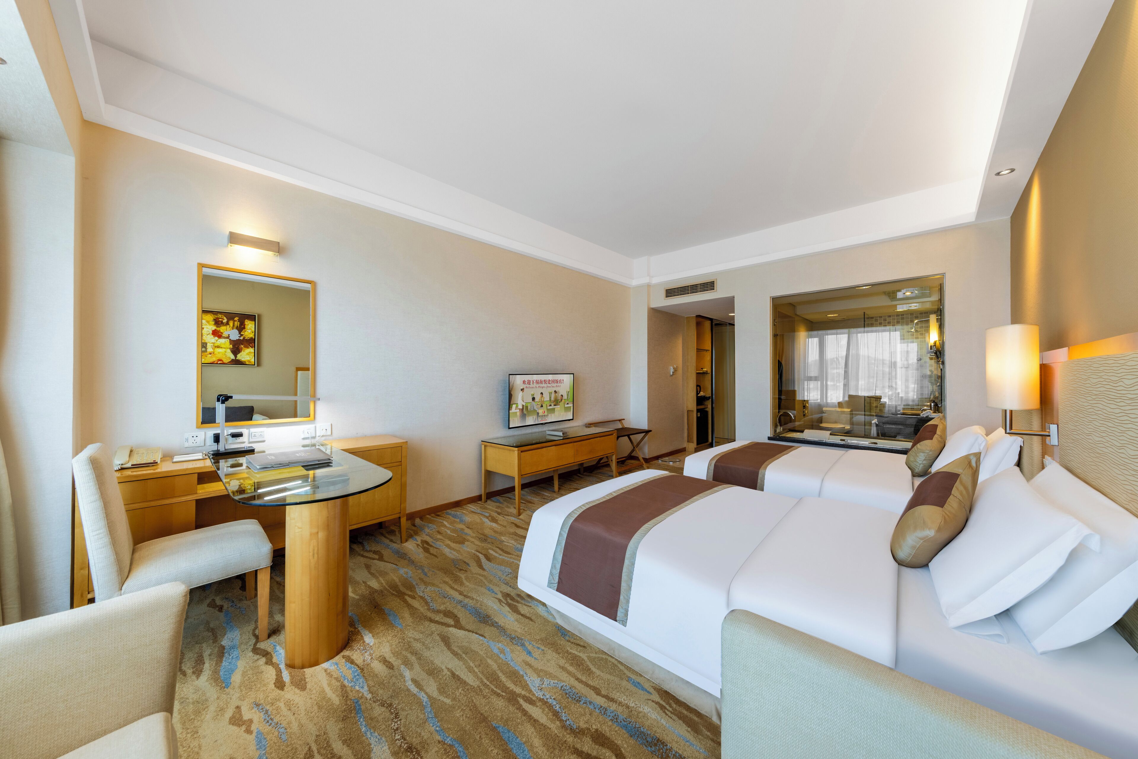 Una habitación de hotel con cama, escritorio, silla, televisor y espejo.