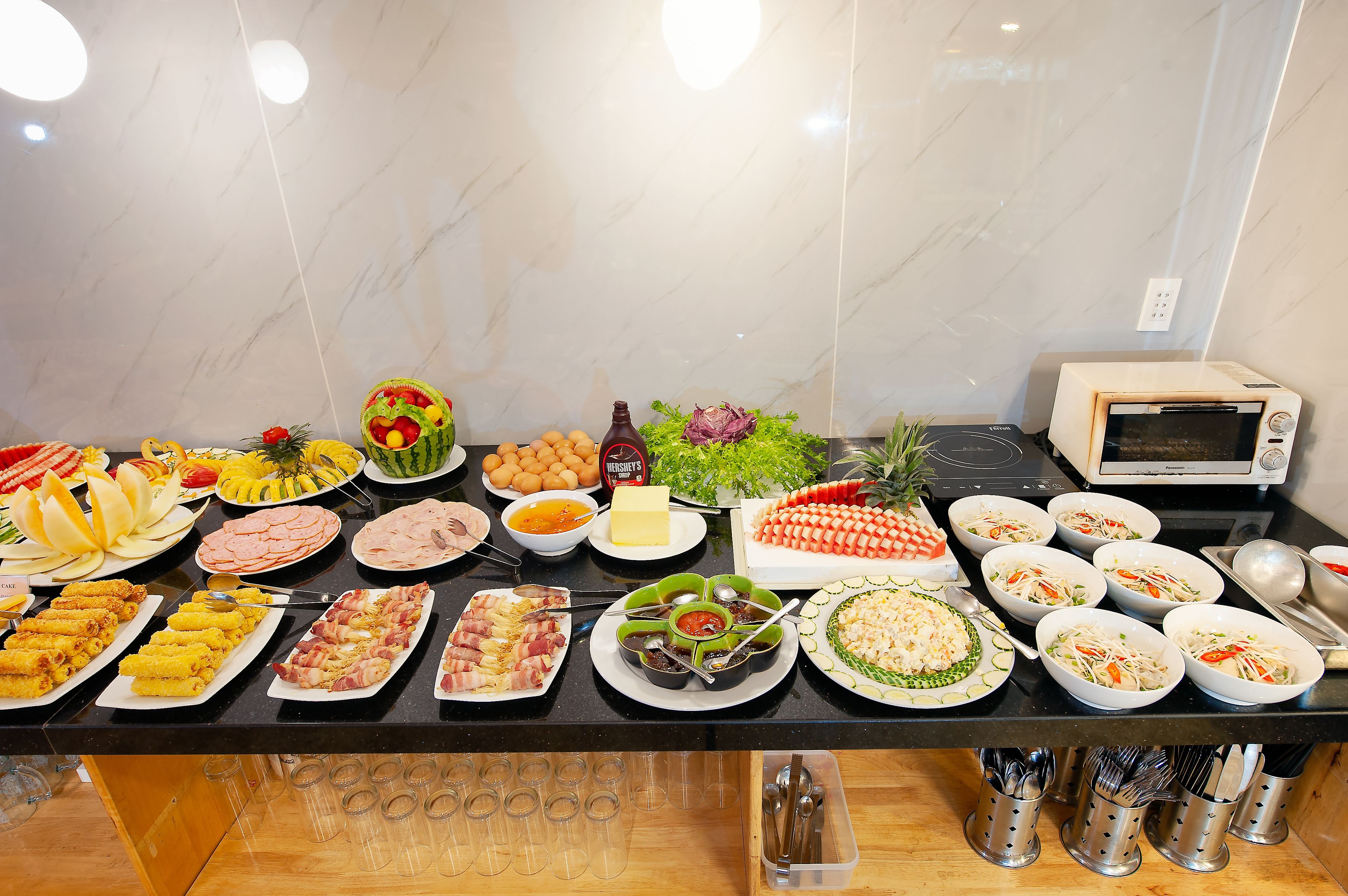Una mesa de buffet con diversos alimentos y salsas.