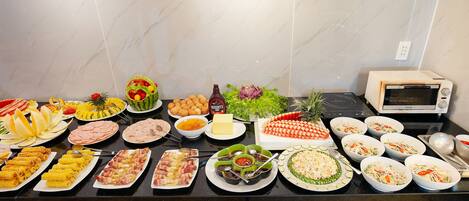 Una mesa de buffet con diversos alimentos y salsas.