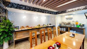 Un restaurante con mostrador de mármol, sillas de madera y una zona de bufé.