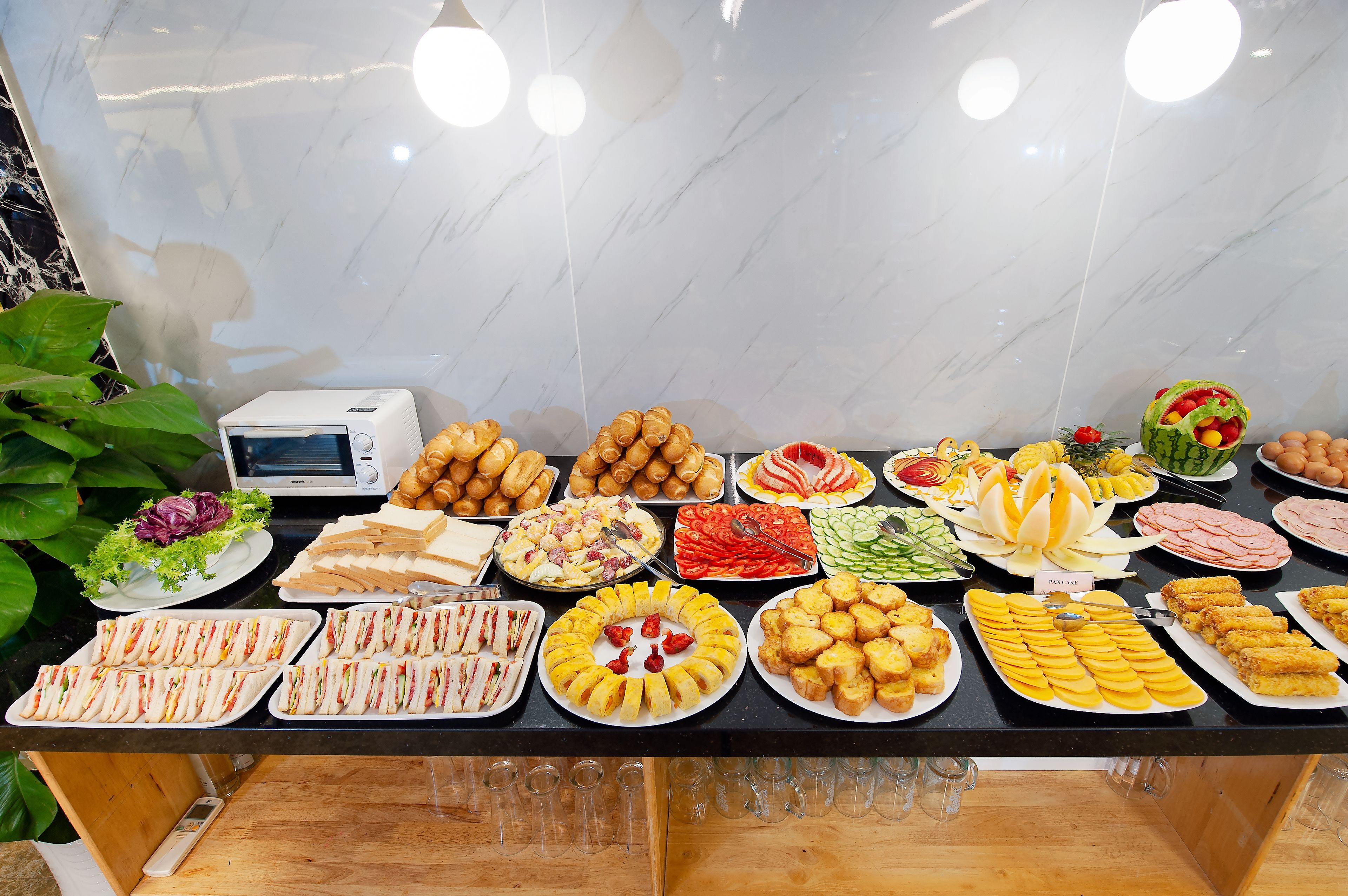 A buffet table with various food items and a microwave.