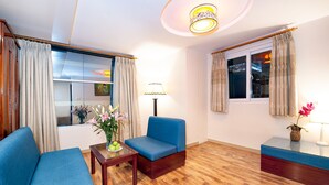 Een moderne woonkamer met een blauwe bank, een tafeltje met een vaas en een lamp.