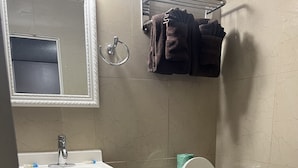 Un baño con inodoro, lavamanos y espejo.