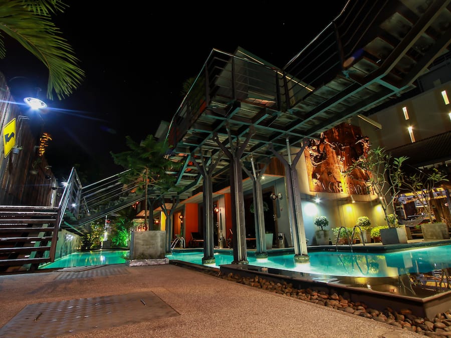 Een buitenzwembad, ligstoelen bij het zwembad