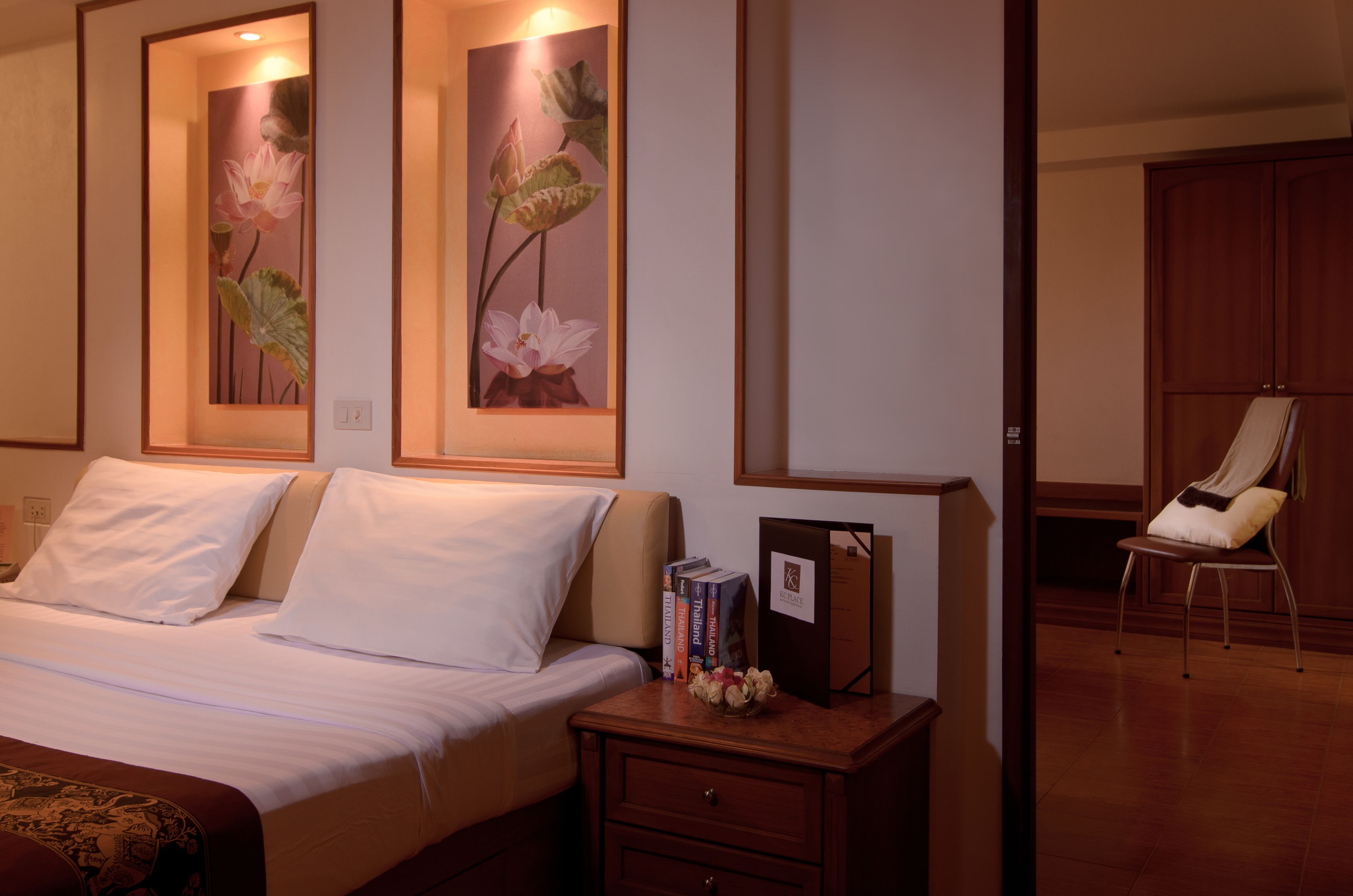 Ein Hotelzimmer mit Bett, Nachttisch und Stuhl.
