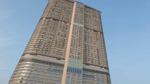 A tall, modern skyscraper with a curved facade and numerous windows. - Delta Lounge (Kowloon)