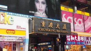 A busy street with a large sign for Chungking Mansions. - Ashoka Hostel (Kowloon)