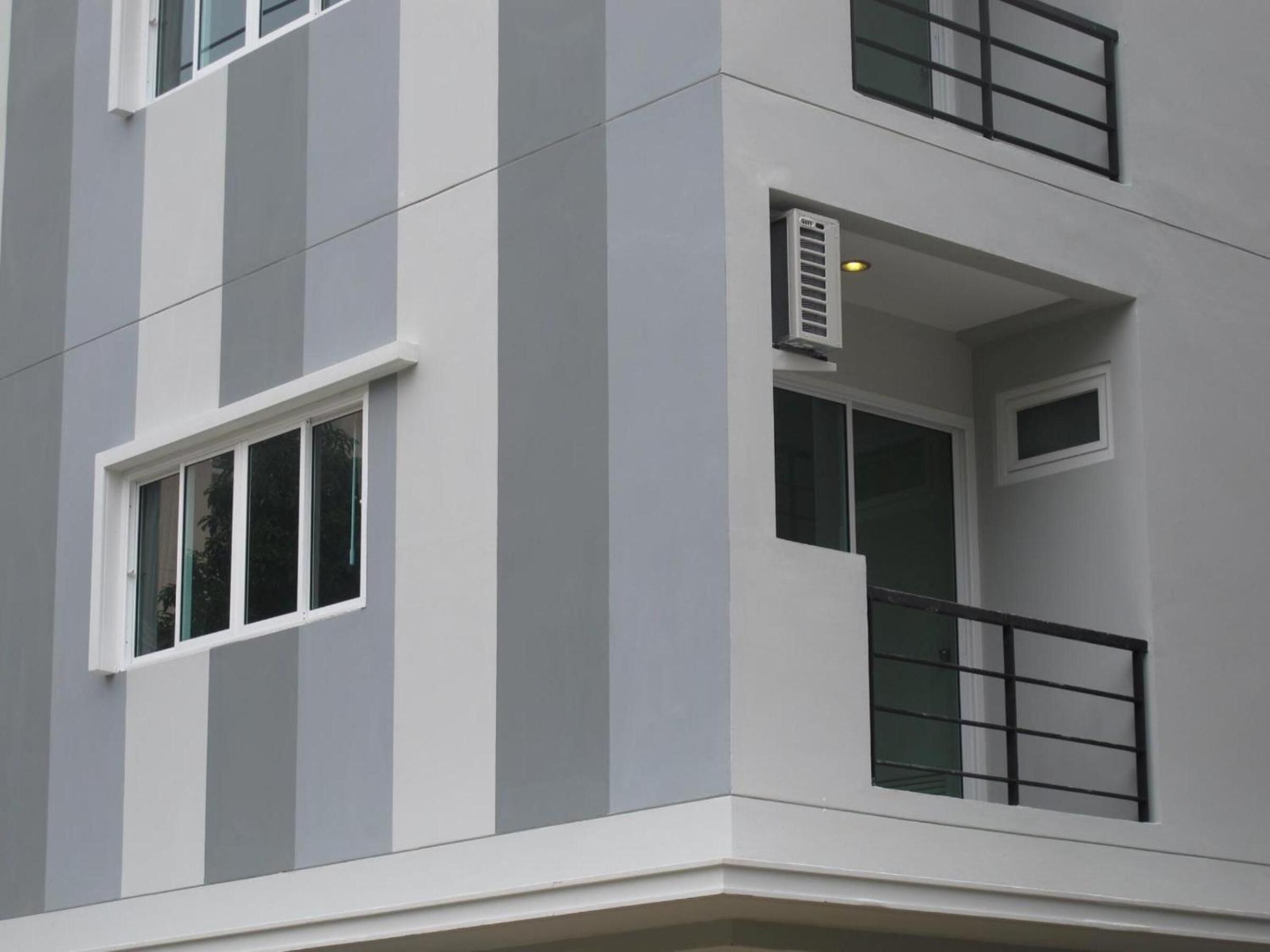 A multi-story building with a modern architectural style, featuring large windows and a balcony.