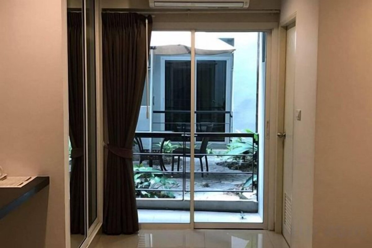 A room with a sliding glass door leading to a balcony with a table and chairs.