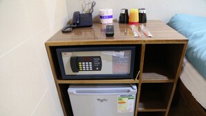 A compact minibar with a refrigerator, a microwave, and a phone. - Australian Guest House (Kowloon)