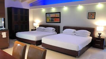 A hotel room with two beds, a desk, and a chair. There are two bedside tables with lamps. The room has a tiled floor and a ceiling with blue lighting.
