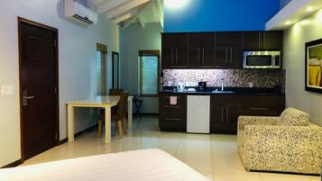A compact living space with a kitchenette, a dining area, and a sofa.