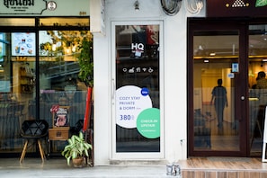 A hotel entrance with a sign advertising a cozy stay option for 380 units.