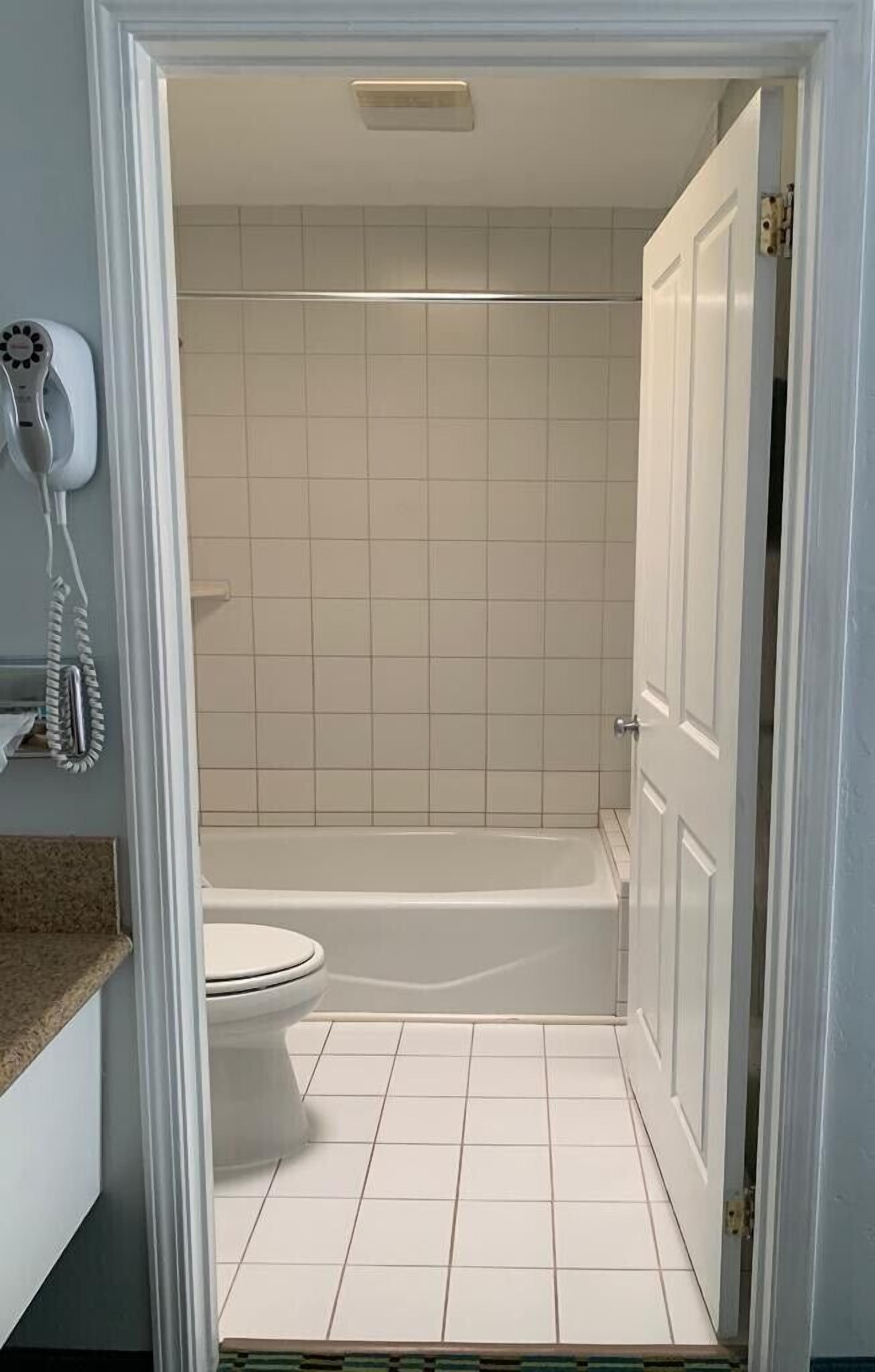 A bathroom with a toilet, a bathtub, and a shower.