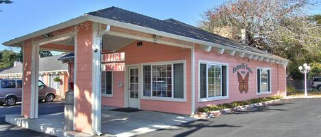 A pink building with a sign that reads "Office" and "Butterfly Inn."