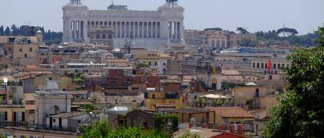 A cityscape with a prominent classical building featuring columns and statues.