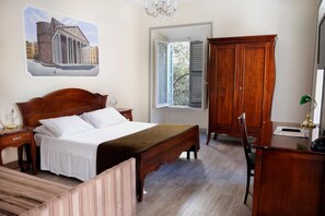 Une chambre à coucher avec un lit, une armoire en bois, un bureau et une fenêtre avec des volets.