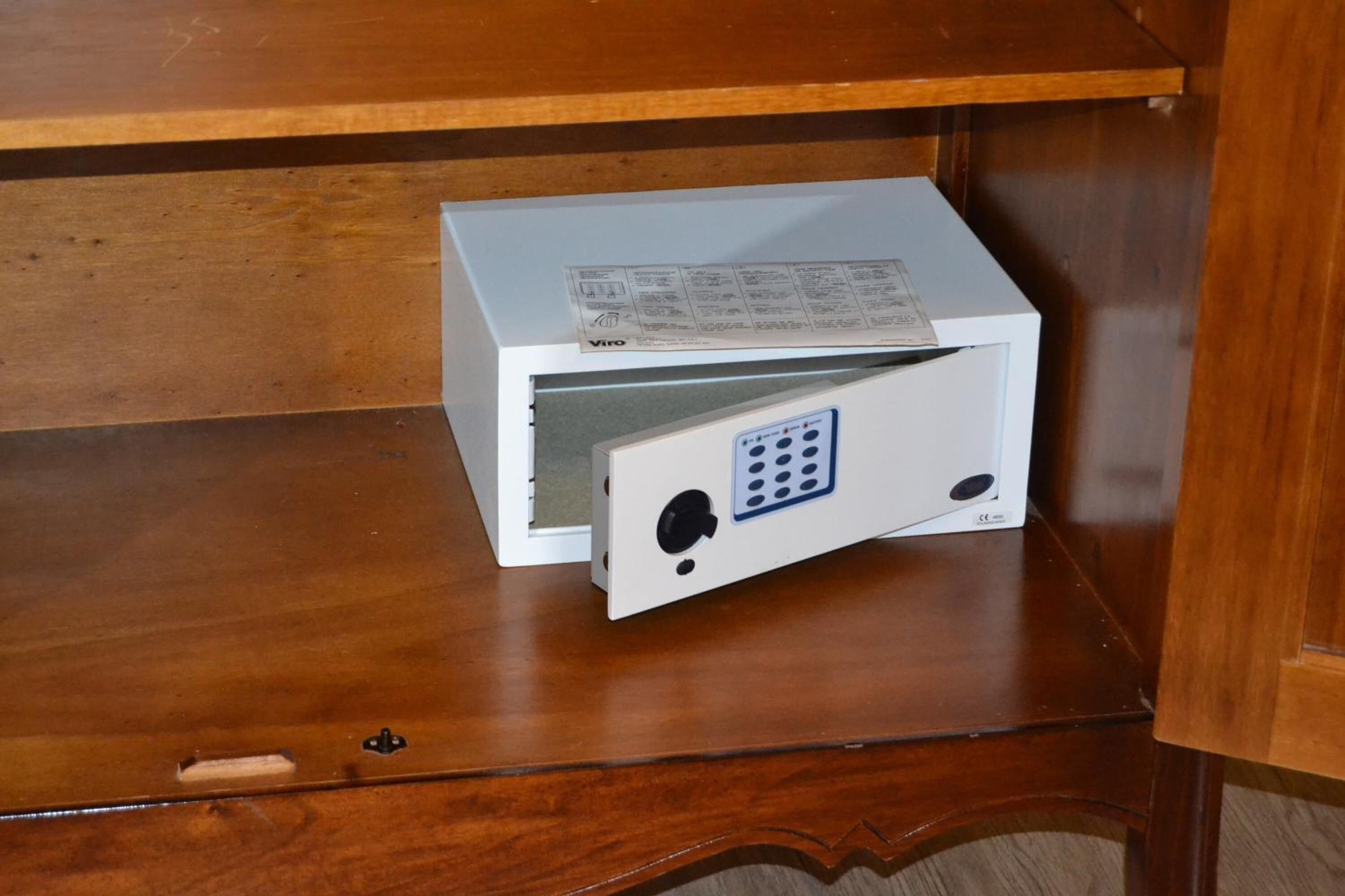A white electronic device with a control panel on a wooden surface.