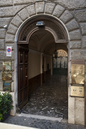 An entrance with a stone archway, a no parking sign, and several plaques on the walls. - Sleep in Rome Ludovisi (Rome)