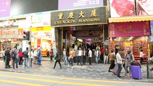 A busy street with a prominent sign for 'Chungking Mansions'. - Tokyo Hostel (Kowloon)