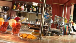 Een barruimte met verschillende drankdispensers, glazen met drank en een schaal lekkernijen.