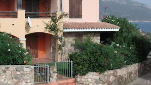 Une maison à deux étages avec une façade en pierre, un toit en tuiles et un balcon.