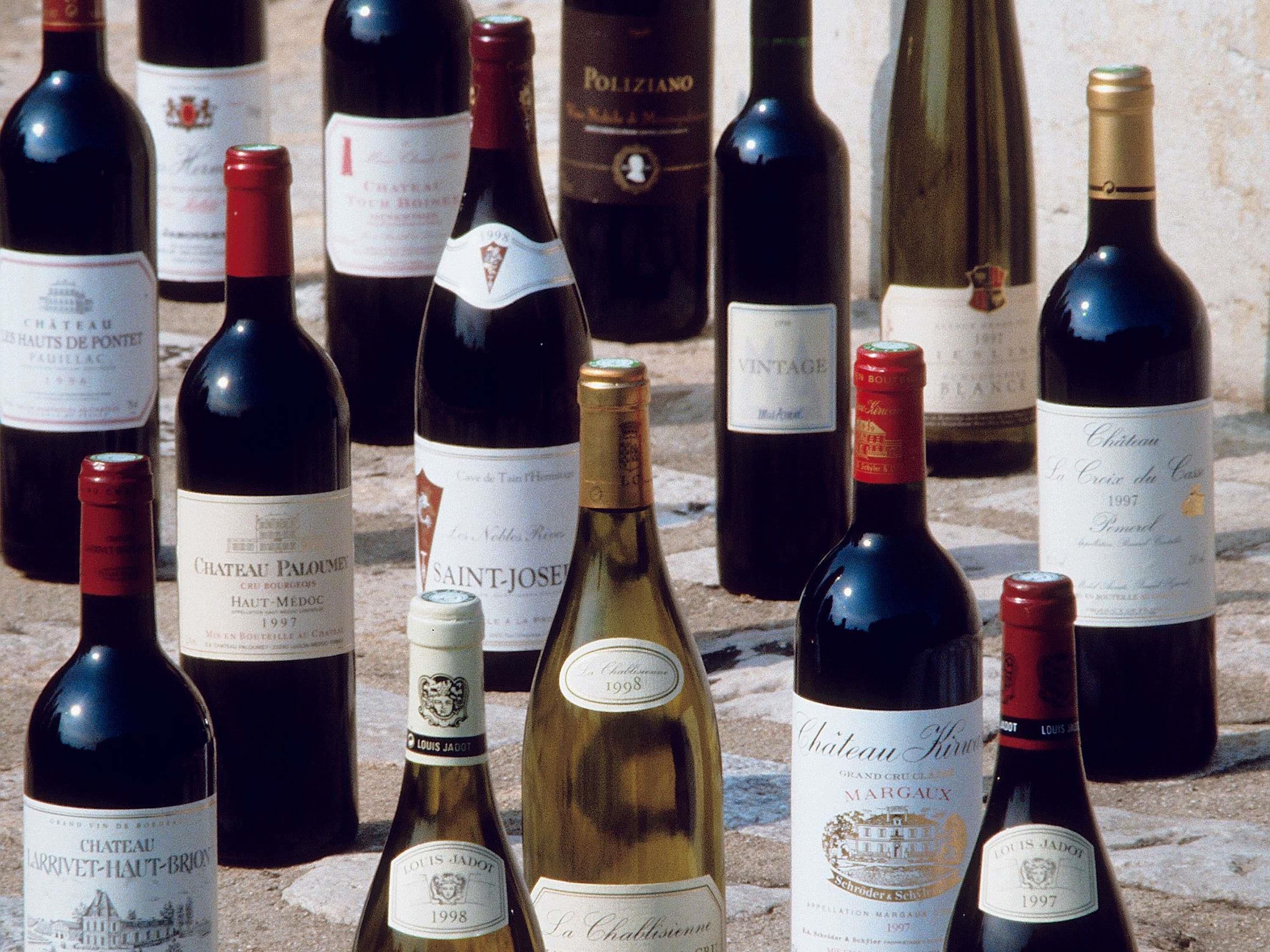 Une collection de bouteilles de vin dont les étiquettes indiquent différentes marques et différentes années.