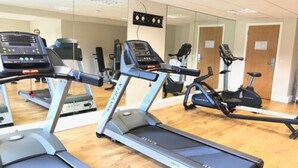 A gym with treadmills, stationary bikes, and a mirrored wall. - Mercure Thame Lambert Hotel (Watlington)