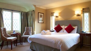 A hotel room with a large bed, two armchairs, a desk, and a nightstand. - Mercure Thame Lambert Hotel (Watlington)