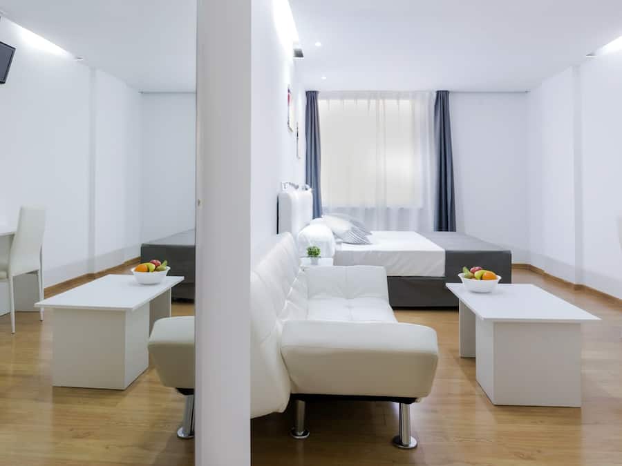 Escritorio, cortinas blackout y tabla de planchar con plancha