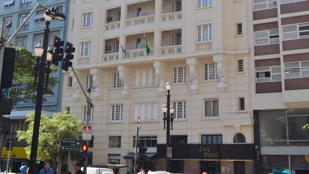 A multi-story hotel with a classic architectural design, featuring balconies and a prominent entrance. - Hotel Lux (São Paulo)