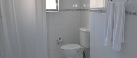 A bathroom with a toilet, sink, and shower curtain.