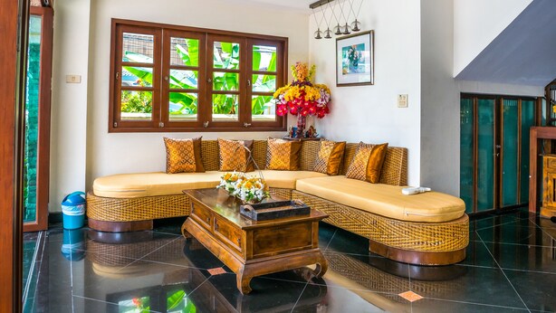 A living room with a sofa, a coffee table, and a decorative vase. - Chomsin Hua Hin (Hua Hin)