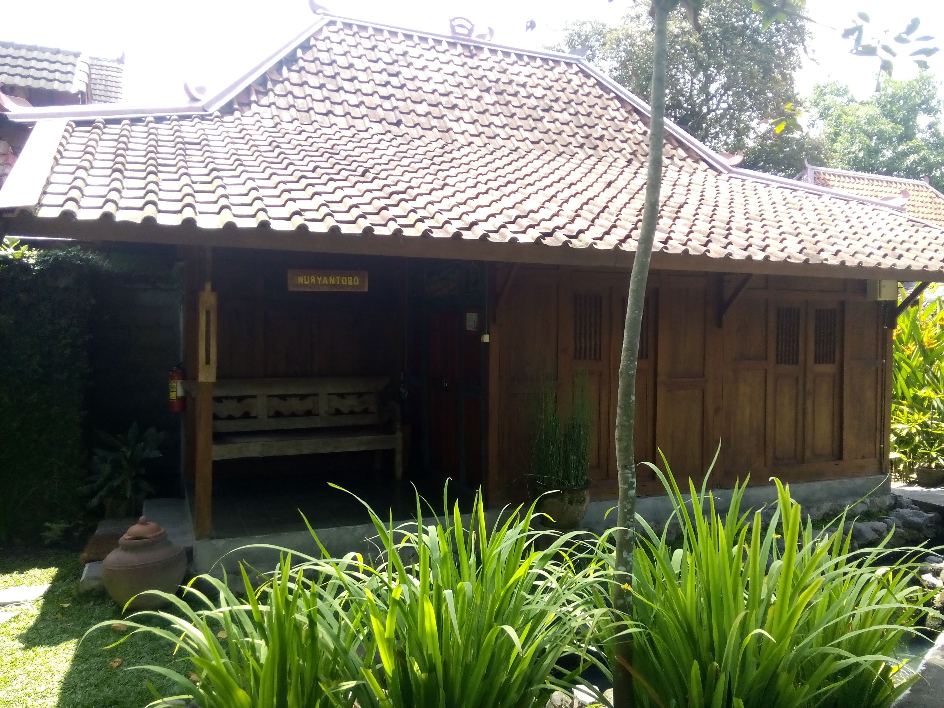 Un bâtiment traditionnel en bois, doté d’un toit en tuiles et d’une enseigne portant l’inscription « MURYANTORO ».