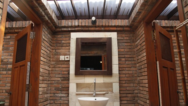 Un baño con un lavamanos grande, un espejo y puertas de madera.