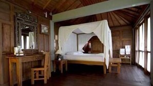 A wooden room with a bed, a desk, and a chair.