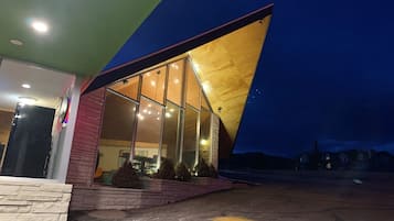 A modern building with large glass windows and a sloped roof.
