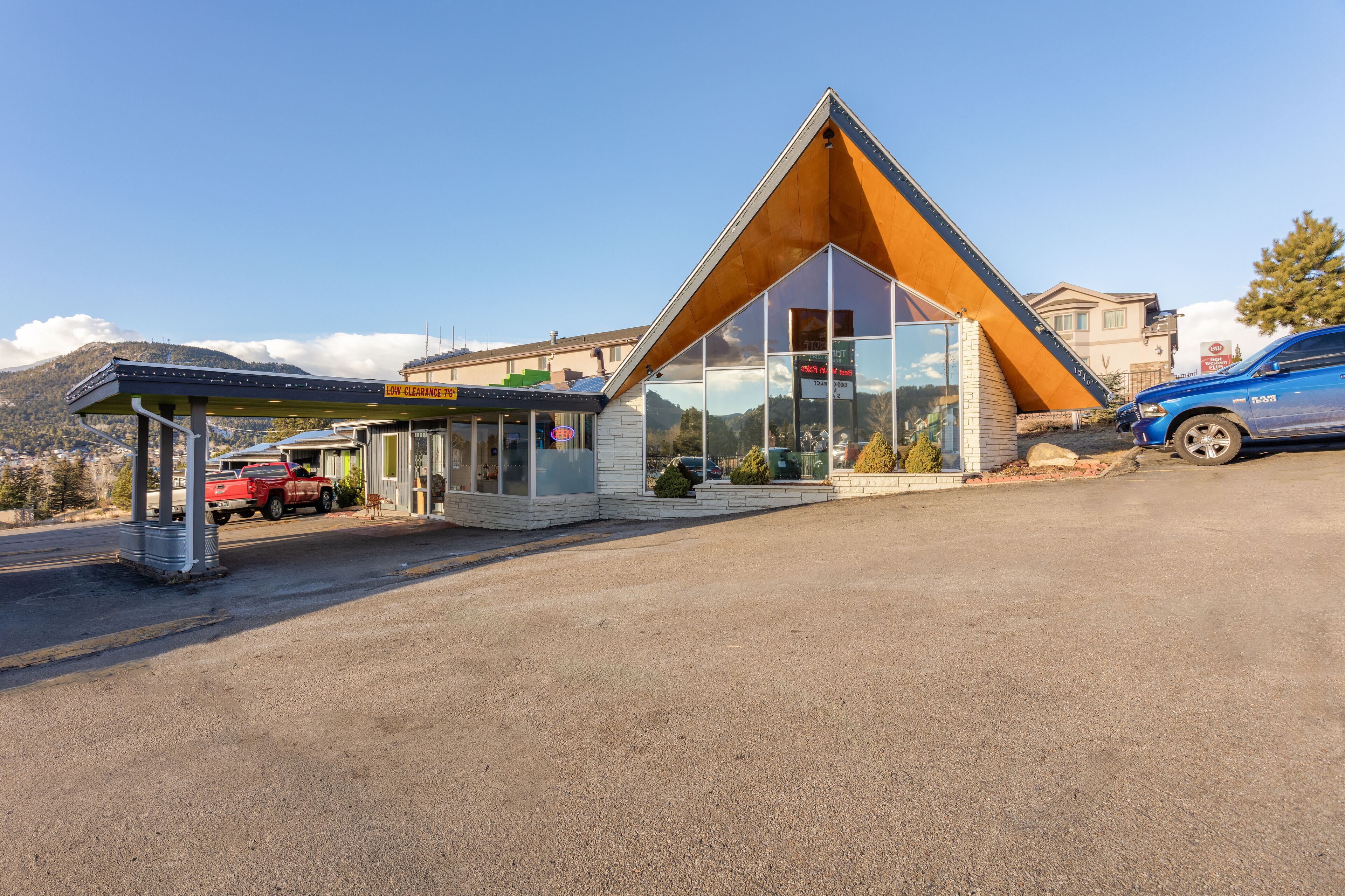 A modern building with a triangular roof, large windows, and a covered entrance.