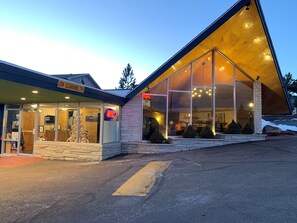 A modern building with large glass windows and a sloped roof. - Coyote Mountain Lodge (Estes Park)