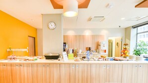 Una zona de recepción con un mostrador de madera, un reloj y diferentes estaciones de comida y bebidas.