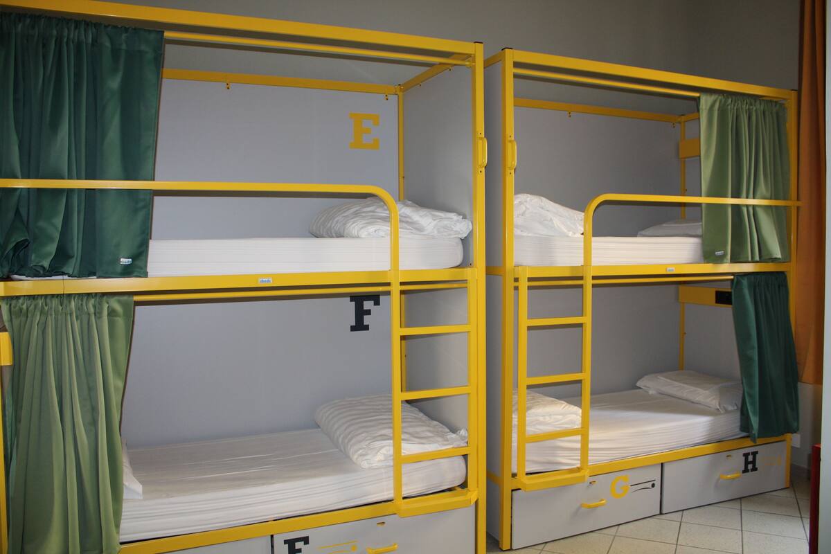 Camas literas con cortinas, identificadas con las letras E, F, G y H.