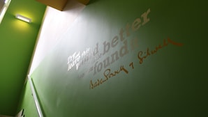 Una pared verde con texto y una nota escrita a mano.