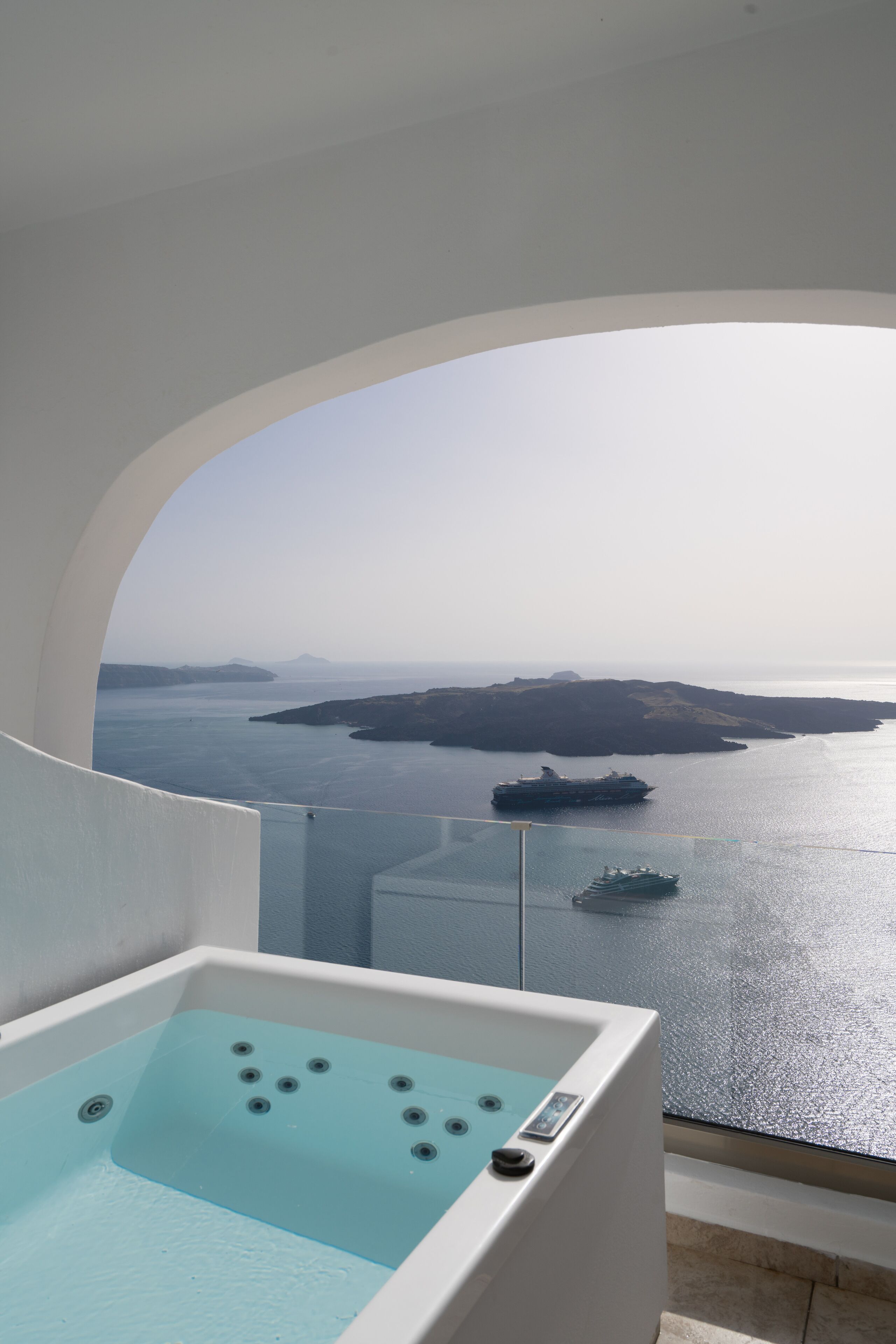 A modern bathroom with a bathtub and a view of the sea.