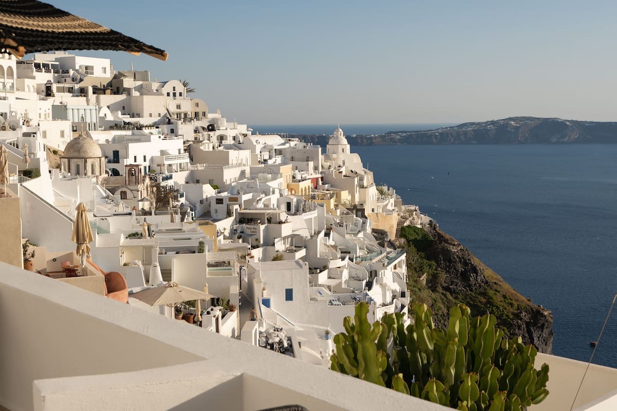 Eine Terrasse mit Blick auf weiße Häuser und das Meer.