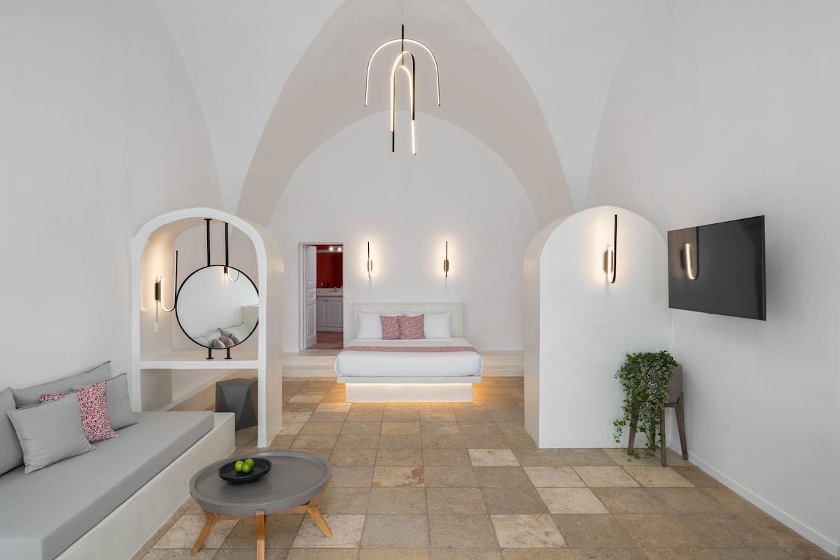 Ein modernes Interieur mit einer Couch, einem Esstisch und einem Bett mit integrierter Beleuchtung.