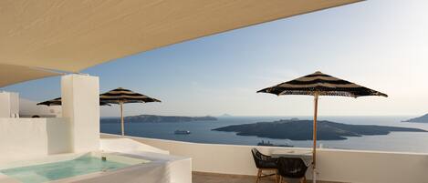 Una terraza en la azotea con piscina, sillones de descanso y sombrillas, con vistas panorámicas del mar y las islas.